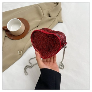 Detail of red heart-shaped mini bag with sparkly rhinestones and silver chain strap