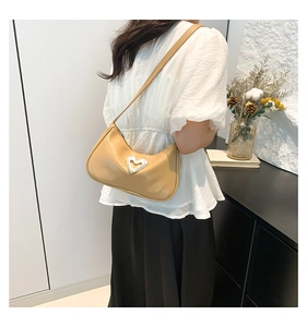 Khaki PU leather underarm bag with crystal heart buckle worn by a model in soft lighting