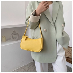 Fashionable yellow PU leather baguette shoulder bag shown on model in mint green suit