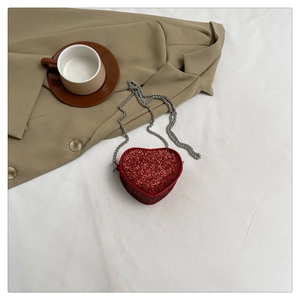 Detailed view of a red sequined heart-shaped mini bag with a fine silver chain strap