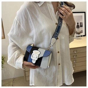 Close-up of color-block crossbody bag with wide letter strap and fashion white buckle