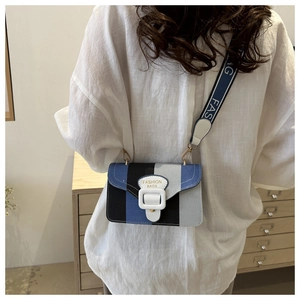 Detail of color-block crossbody bag with vertical stripes and wide lettered strap