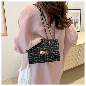 Detail of tweed crossbody bag featuring metallic chain strap and gold twist lock closure