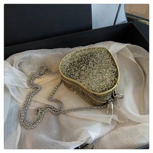 Detail of heart-shaped evening bag with gold rhinestones, silver chain and gift box