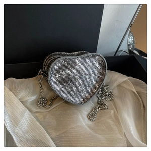 Macro shot of silver heart evening clutch with shiny rhinestones and metal chain