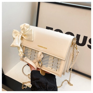 Detail of crossbody bag with silk bow, geometric texture and gold chain strap
