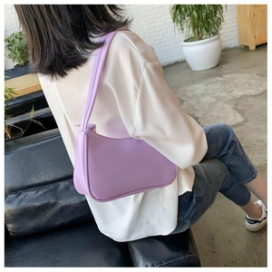 Close-up of minimalist lavender matte leather baguette bag worn with a white shirt
