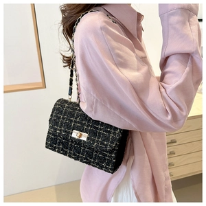 Classic black and gold tweed shoulder bag detail showing the metal chain strap and turn-lock