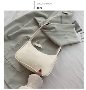 Close-up of minimalist cream white faux leather underarm bag with zipper detail