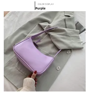 Detail view of a purple minimalist faux leather baguette bag on a stylish blazer