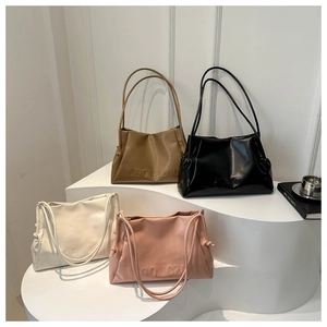 Close-up of four minimalist tote bags in tan, black, beige, and pink with embossed logos
