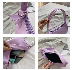Detail view of lilac PU leather underarm bag featuring bow decor and metal zipper