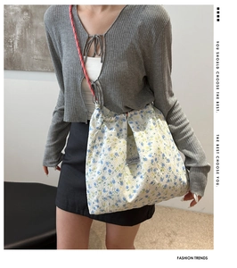 Detailed close-up of floral nylon bag with braided rope strap and fashion label