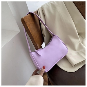 Detail of a minimalist lavender baguette bag hanging on a vintage wooden chair