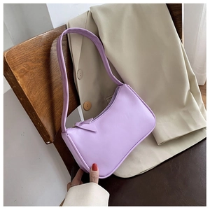 Chic light purple leather underarm bag placed on a wooden chair with a beige blazer