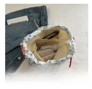 Detail shot of floral drawstring bucket bag showing interior capacity and inner pocket