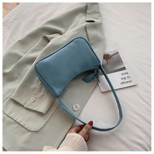 Detail showing smooth light blue vegan leather hobo bag with a minimalist moon shape design