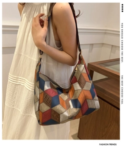 Detail of multi-color patchwork hobo bag featuring embossed crocodile texture patterns