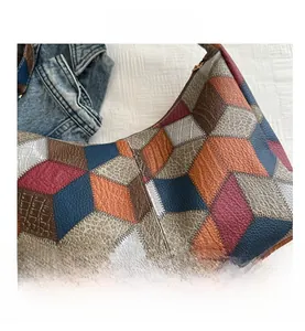 Detailed close-up of patchwork leather tote showing stitching and mixed embossed textures