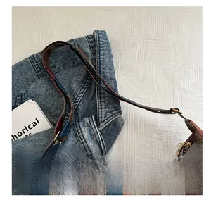 Detail of adjustable shoulder strap and color-block pebbled leather on tote bag