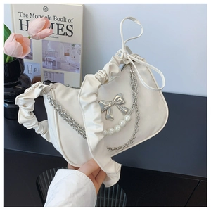Detail of off-white dumpling bag featuring ruffle handle and elegant pearl chain accents