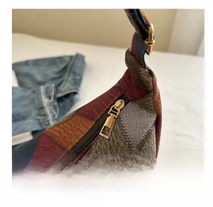 Close-up of smooth golden metal zipper on a colorful patchwork faux leather tote bag