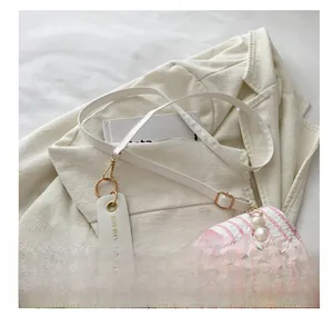 Vue détaillée du petit sac polochon fleuri avec chaîne en perles et étiquette mode