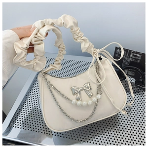 Detail of off-white dumpling bag with silver bow, metallic chains and pearl strap