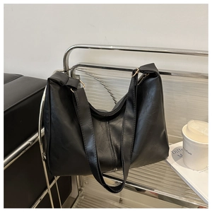 Detail of a large black vintage tote bag with soft PU leather texture and a top zipper