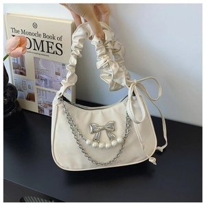 Detail of a creamy white hobo bag with pearl bow hardware and ruched cloud handle
