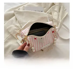 Vue détaillée du sac bandoulière à rayures roses avec imprimés fraises et perles