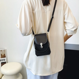 Black minimalist crossbody phone bag with silver buckle and adjustable shoulder strap