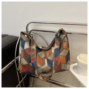 Detail of color-block tote bag featuring lychee grain leather and golden metal hardware