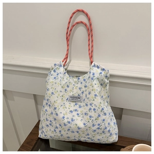 Close-up of floral nylon tote with orange woven rope handle and fashion label