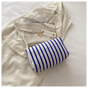 Detailaufnahme der blau-weiß gestreiften Stoffhandtasche auf einem Blazer