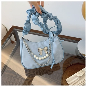 Light blue pleated shoulder bag featuring a silver bow and elegant pearl chain details