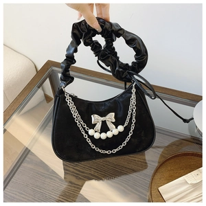 Detail of black velvet underarm bag with silver bow and pearl chain pendant decoration
