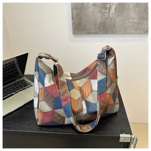 Close-up of retro patchwork tote bag with various colorful leather textures on a table