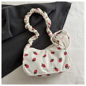 Detail of strawberry print corduroy shoulder bag with ruffled strap and side ribbon knot
