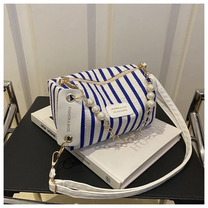 Detail der blau gestreiften Zylindertasche mit Perlenkette und Leder-Schultergurt