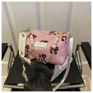 Detailansicht der rosa Zylindertasche mit Katzenprint und Perlenblumenkette