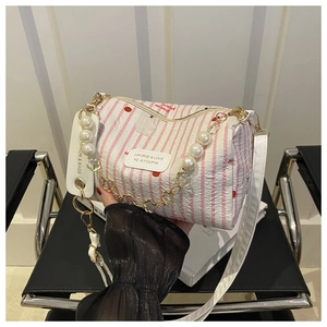 Detail der weiß gestreiften Zylindertasche mit Kirschprint und Perlenkette