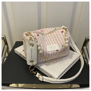 Detailansicht der gestreiften Mini-Zylindertasche mit Perlenkette und Kirschmuster
