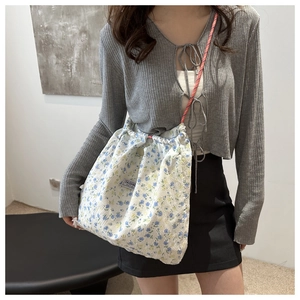 Floral nylon drawstring shoulder bag with floral pattern and orange braided strap