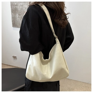 Detail view of cream-white large capacity tote bag featuring geometric textured leather