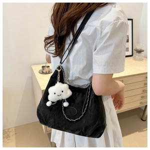 Black PU shoulder bag with silver chain and white cloud plush charm on a female model