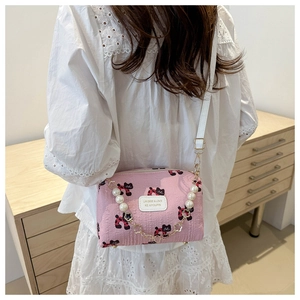Sac bandoulière rose avec imprimé chat, poignée en perles et sangle en cuir sur modèle