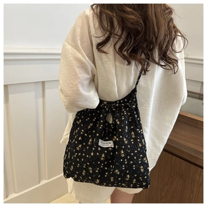 Floral nylon shoulder bag with drawstring closure and yellow flower patterns on black