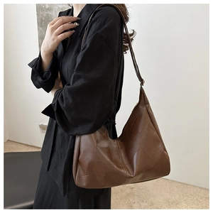 Detail shot of vintage brown leather hobo shoulder bag with geometric stitching