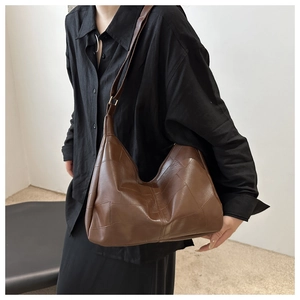 Detail of deep brown patchwork faux leather tote bag showing unique stitched rectangle panels